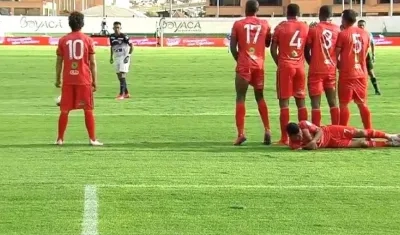 Cristian Barrios se acuesta detrás de la barrera ante el cobro de tiro libre de los junioristas.