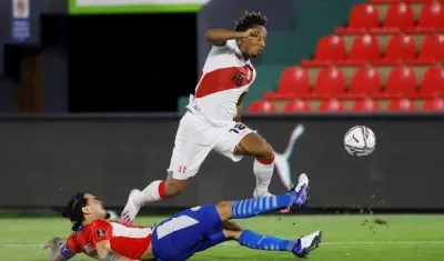 Gustavo Gómez de Paraguay disputa un balón ante André Carrillo de Perú.