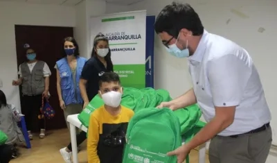 Entrega de ayuda a un niño hijo de migrantes venezolanos.