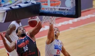 Jonathan Rodríguez encesta para Titanes, ante el acoso de un rival. 