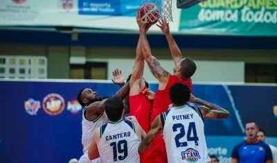 Gianluca Bacci y Jonathan Rodríguez luchan bajo el aro, ante la marca de tres jugadores del Team Cali.