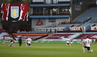 Jugadores de rodillas antes del inicio de un partido. 