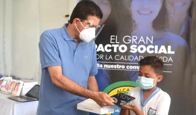El Alcalde Rodolfo Ucrós entregando la tablets a uno de los estudiantes.