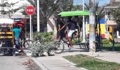 Una persona movilizándose en bicitaxi por el sendero de un parque.