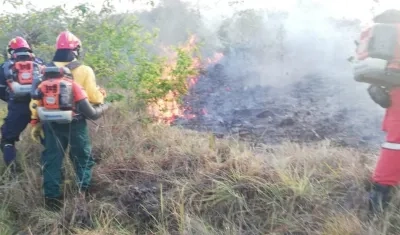 El incendio es controlado por bomberos.