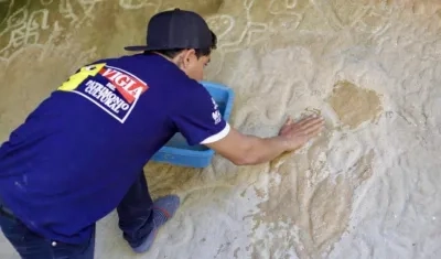 Uno de los 7 Vigías del Patrimonio restaurando la figura.