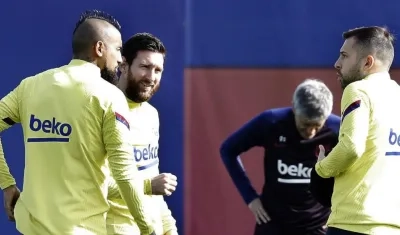 Arturo Vidal y Lionel Messi hablan con Jordi Alba. 
