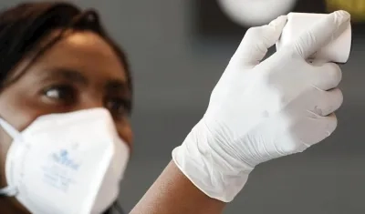 Funcionarios toman la temperatura de los ciudadanos que llegan este jueves al aeropuerto internacional El Dorado