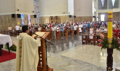 Sacerdote y feligreses durante misa.