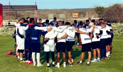 Jugadores de Junior reunidos con los entrenadores antes de iniciar un entrenamiento. 