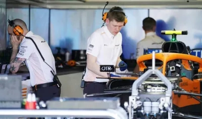 Técnicos del equipo McLaren revisan el monoplaza de carreras. 