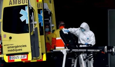 Un técnico sanitario desinfecta la camilla de una ambulancia en la entrada de urgencias del Hospital de Bellvitge.