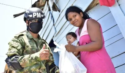 Un miembro de la Policía Militar apoya la labor de entrega de mercados en los barrios Las Flores, Siape y La Playa.