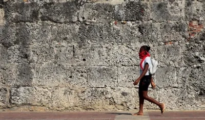 Una joven en Cartagena transita por una de las calles de la ciudad amurallada.