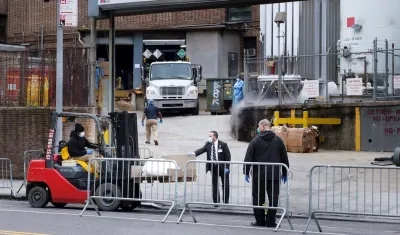 Los empleados del hospital transfieren un cuerpo en una carretilla elevadora a una morgue móvil temporal, puesto en su lugar debido a la falta de espacio en el hospital, fuera del Brooklyn Hospital Center en Brooklyn.