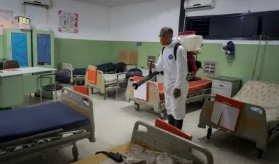 Un miembro de protección civil desinfecta un hospital comunitario.