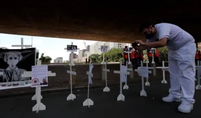 Cruces blancas con fotografías de personal médico fallecido por la crisis del Covid-19 son instaladas en la Avenida Paulista, en Sao Paulo.