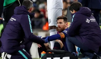 Lionel Messi atendido por los médicos en un partido del Barcelona. 