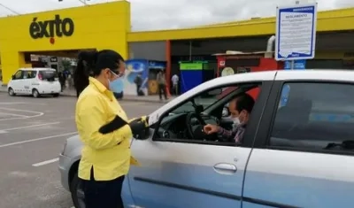 Empleada de Éxito atendiendo a cliente en uno de los puntos de 'Compra y recoge'.