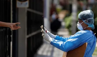 Trabajadores del ministerio de Salud toman muestras a domicilio para pruebas de coronavirus en Lima (Perú).