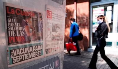 Una mujer, con tapaboca, camina junto a un kiosko en la comuna de Providencia en Santiago (Chile).