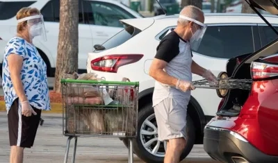 Personas haciendo compras en el estado de la Florida con todas las medidas de seguridad.