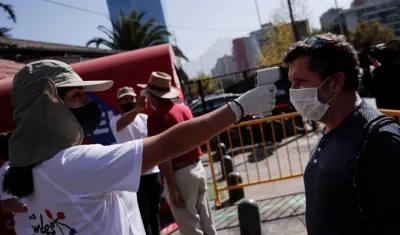 Toma de temperatura a personas que van a abastecerse en centros comerciales de Santiago de Chile.