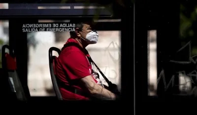Un usuario protegido con una mascarilla en un bus.