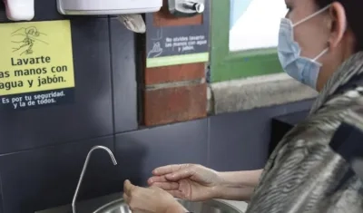 Una mujer se desinfecta sus manos en un lavamanos público.