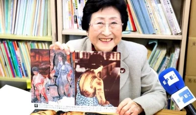 La superviviente de la bomba atómica de Hiroshima, Michiko Kodama sonríe mientras muestra una lámina que representa los efectos de la explosión de la bomba atómica.