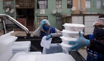 Dirigentes vecinales y trabajadores municipales reparten almuerzos a familias vulnerables en la comuna de Puente Alto el 12 de mayo de 2020, en Santiago (Chile).