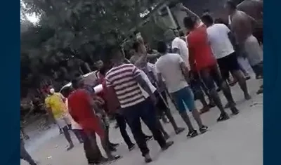 Agrupados, sin tapabocas, viendo la pelea de gallos.