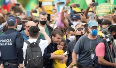 El presidente de Brasil, Jair Bolsonaro, saluda a una niña este domingo, en Brasilia (Brasil).