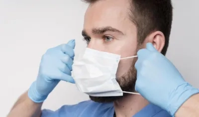 Un enfermero explica el uso del tapabocas.