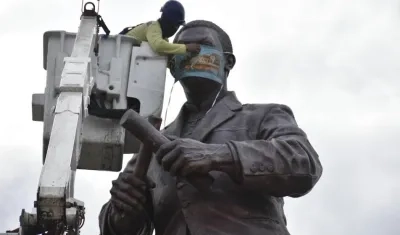 Colocación del tapabocas al monumento del Joe Arroyo.