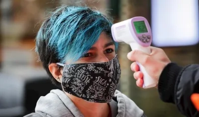 Una mujer entra a un centro comercial con tapabocas.