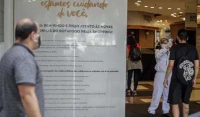 Una trabajadora sanitaria toma la temperatura a personas que entran a un centro comercial en Río de Janeiro.