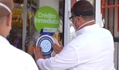 El Alcalde Roberto Celedón colocando el sello de bioseguridad en uno de los negocios.