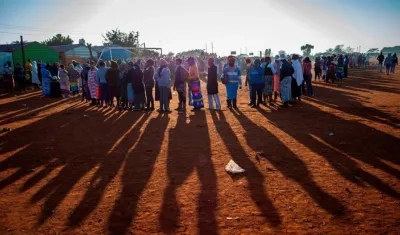 Varios ciudadanos aguardan sin distanciamiento de dos metros para recibir raciones de comida en una población de Sudáfrica. 