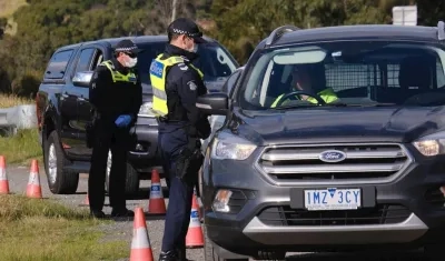 La Policía de Victoria revisa documentos de un conductor en un control cerca de Gisborne, Australia.