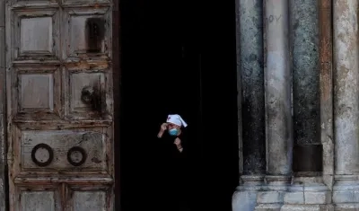 Una monja con mascarilla sale de iglesia del Santo Sepulcro, en Jerusalén.