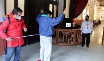 Personal de la Catedral realiza la desinfección de fieles que ingresan a un oficio religioso, este sábado en Santa Cruz (Bolivia). 