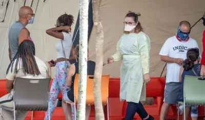 En la imagen, algunas personas usan máscaras y esperan para ingresar al Memorial Regional Hospital en Hollywood, Florida, EE.UU.