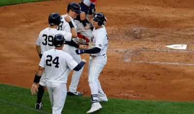Gio Urshela felicitado por sus compañeros tras conectar el Grand Slam.