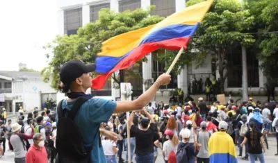 Manifestantes agitando la bandera de Colombia.