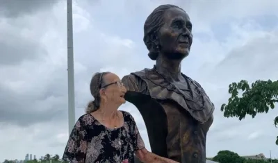 Carmen Mejía al lado de la estatua de Micaela la Valle.