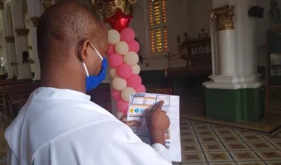 El sacerdote Roberto Rodríguez Padilla, párroco de la Iglesia de Chiquinquirá, muestra el recibo.
