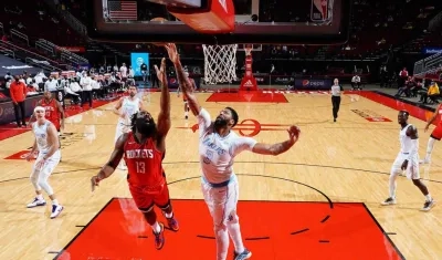 Anthony Davis defiende ante un intento de James Harden. 