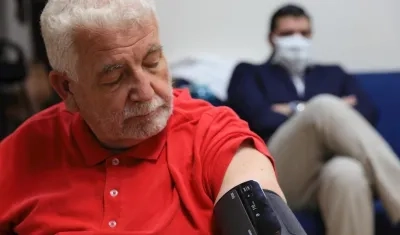 Un hombre espera mientras le toman la presión arterial. 