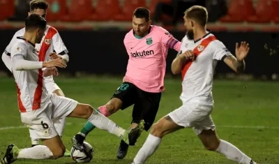 Lionel Messi en acción de juego ante los defensas de Rayo. 